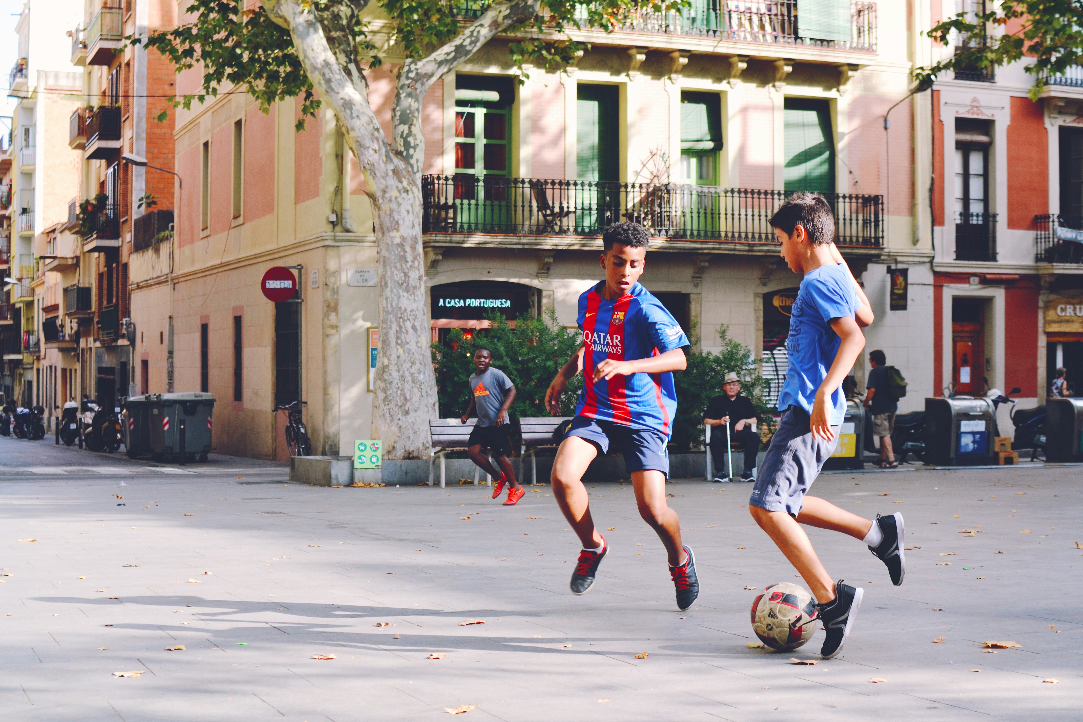 Kids playing small-sided soccer on a street court